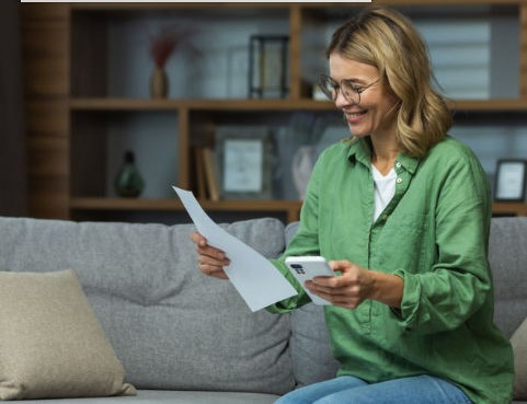 Person reviewing their credit score on paper and phone